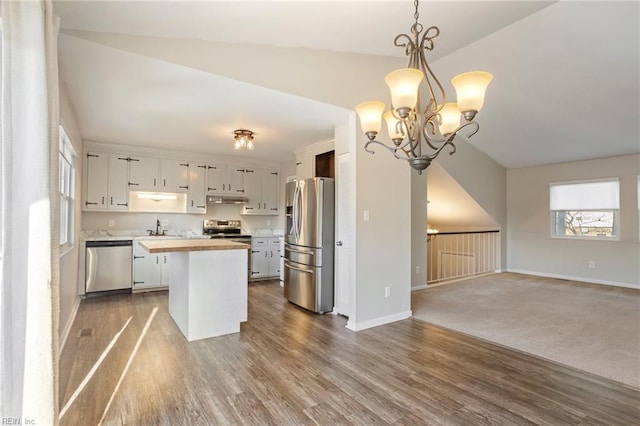 kitchen featuring stainless steel appliances, open floor plan, white cabinets, and pendant lighting