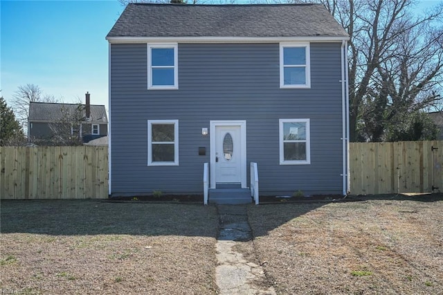 view of front of home featuring entry steps, roof with shingles, and fence