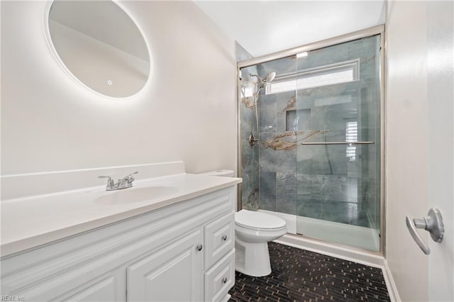 bathroom featuring vanity, a shower stall, and toilet