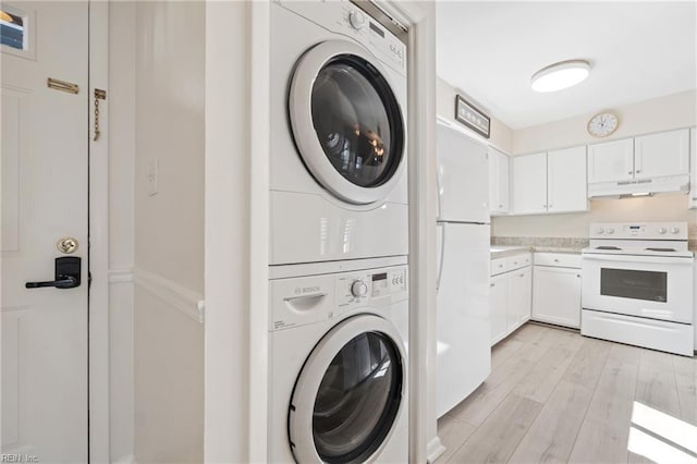 clothes washing area with light wood-type flooring, stacked washer and dryer, and laundry area