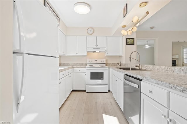 kitchen with light wood finished floors, light countertops, a sink, white appliances, and under cabinet range hood