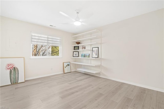 spare room with light wood-style flooring, visible vents, baseboards, and a ceiling fan