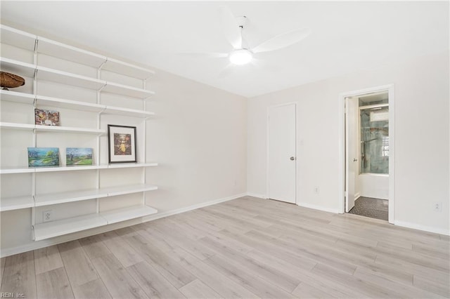 spare room with baseboards, a ceiling fan, and wood finished floors