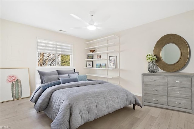 bedroom with a ceiling fan, light wood-type flooring, and visible vents