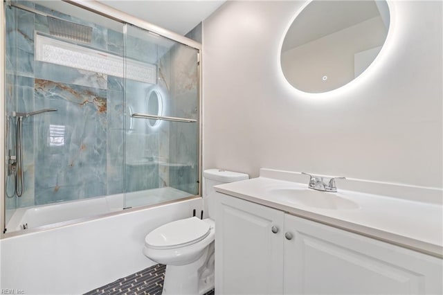 bathroom with shower / bath combination with glass door, vanity, and toilet