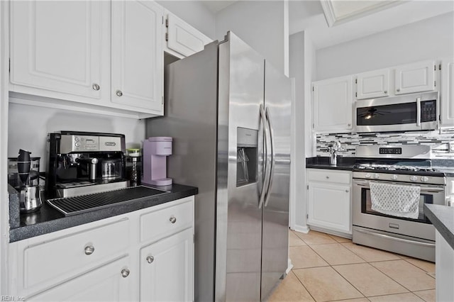 kitchen featuring appliances with stainless steel finishes, dark countertops, and white cabinetry