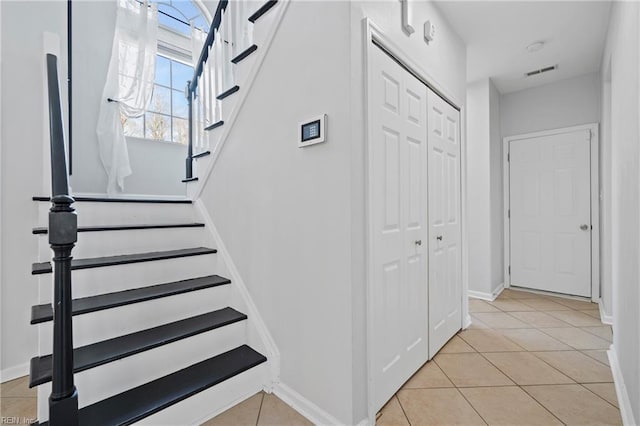 stairs featuring visible vents, baseboards, and tile patterned floors