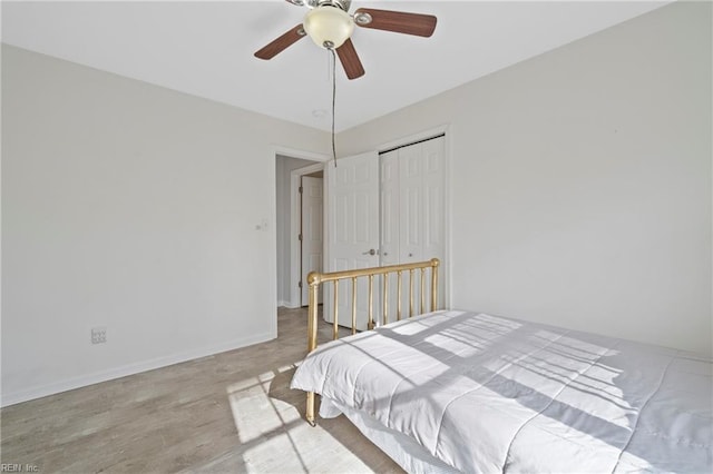 bedroom featuring ceiling fan, a closet, baseboards, and wood finished floors