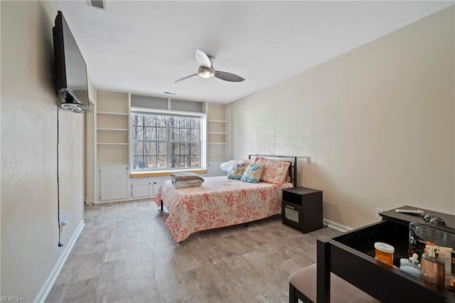 bedroom featuring visible vents, wood finished floors, a ceiling fan, and baseboards