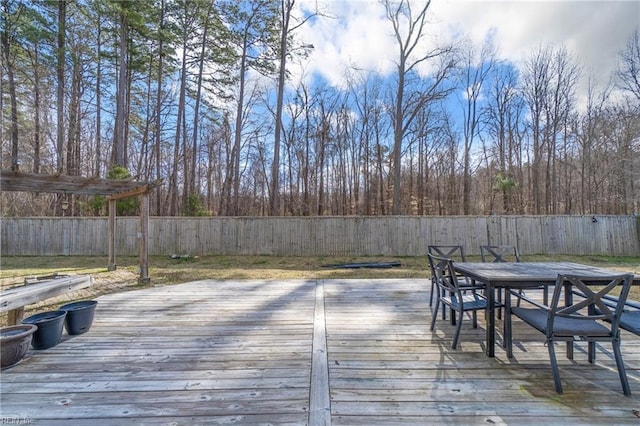 deck featuring outdoor dining area and a fenced backyard