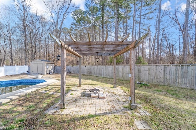 view of yard with an outbuilding, a patio, a storage unit, a fenced backyard, and a fire pit