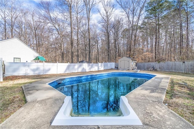 view of swimming pool featuring a storage shed, a fenced in pool, a fenced backyard, an outdoor structure, and a patio area