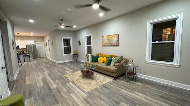 living room with ceiling fan, recessed lighting, wood finished floors, and baseboards