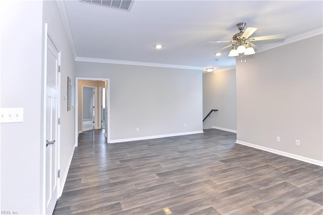 spare room with dark wood-style floors, visible vents, crown molding, and baseboards