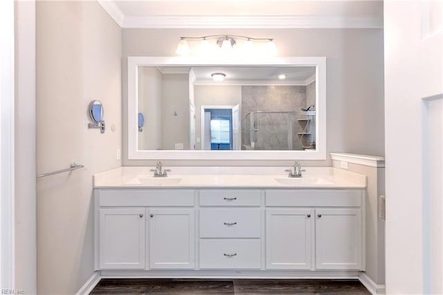 bathroom with double vanity, a stall shower, a sink, and crown molding