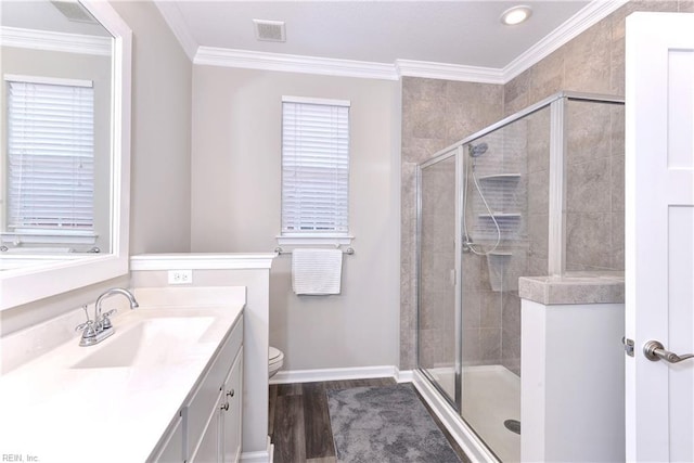 bathroom with ornamental molding, a stall shower, wood finished floors, and visible vents