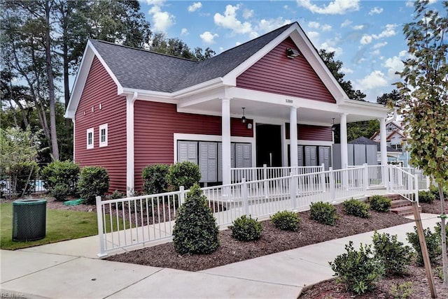 view of front facade featuring a shingled roof and covered porch