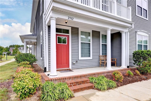 property entrance featuring a porch and a balcony