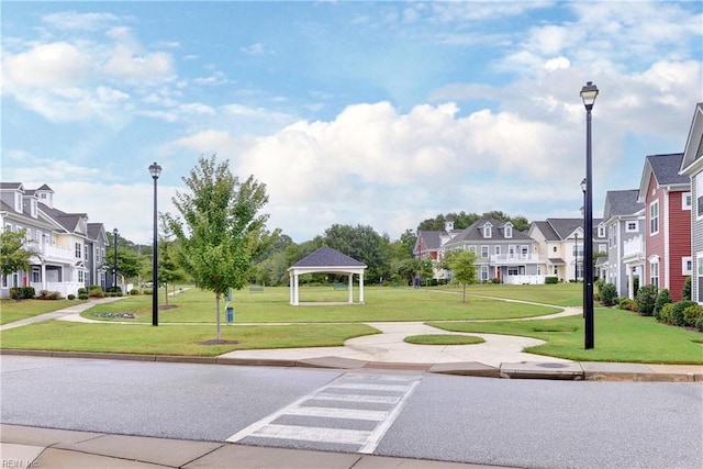 view of community featuring a gazebo, a lawn, and a residential view