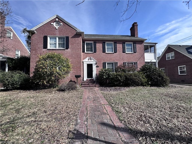 view of front facade featuring brick siding and a chimney