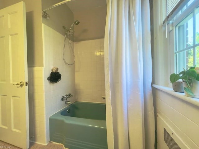 full bathroom featuring shower / tub combo and tile walls