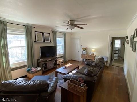 living area with a ceiling fan, ornamental molding, and wood finished floors