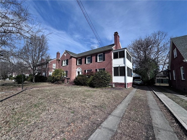 view of side of home with brick siding and a chimney