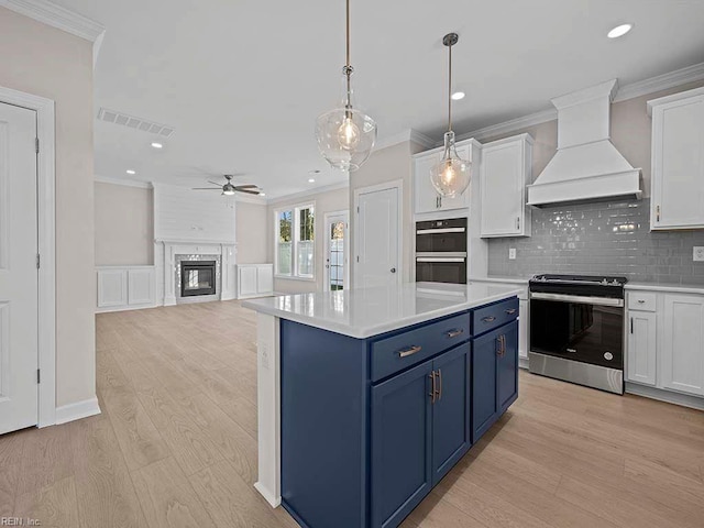 kitchen featuring light countertops, custom range hood, stainless steel electric range, and white cabinetry