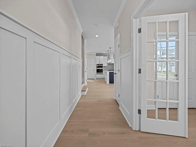 hallway featuring light wood-type flooring, crown molding, and recessed lighting