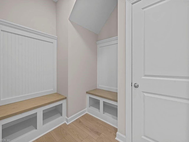 mudroom with lofted ceiling, light wood-style flooring, and baseboards