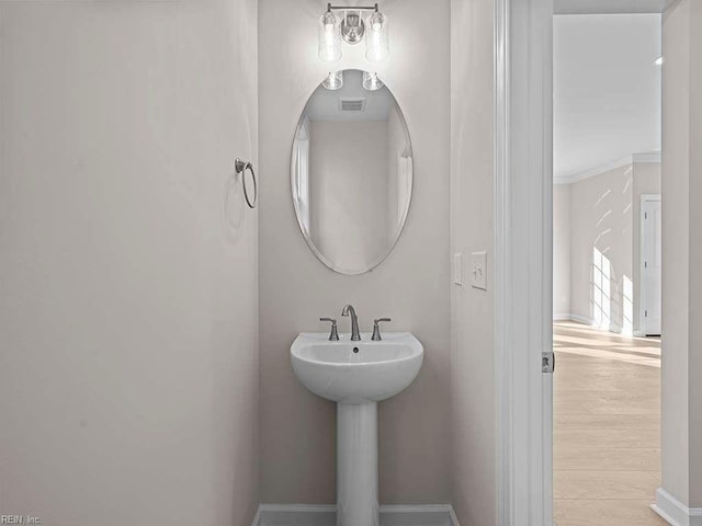 bathroom with visible vents, baseboards, and wood finished floors