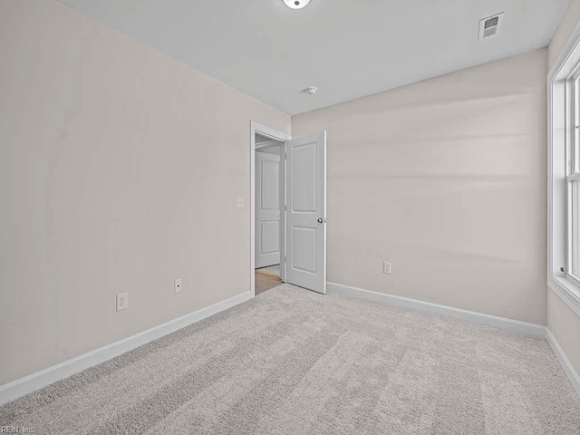 unfurnished room featuring light carpet, visible vents, and baseboards