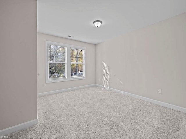 unfurnished room featuring light carpet, visible vents, and baseboards