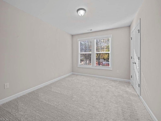 unfurnished room featuring light carpet, visible vents, and baseboards