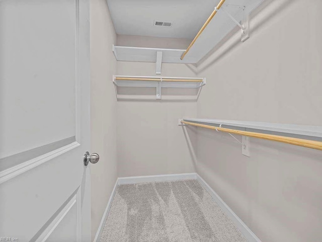 walk in closet featuring visible vents and light colored carpet