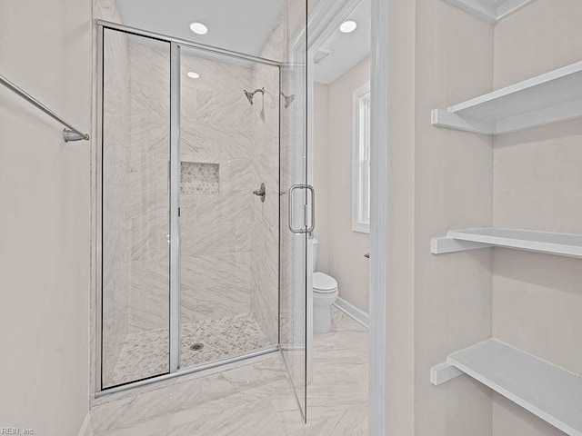 bathroom with marble finish floor, a shower stall, toilet, and baseboards