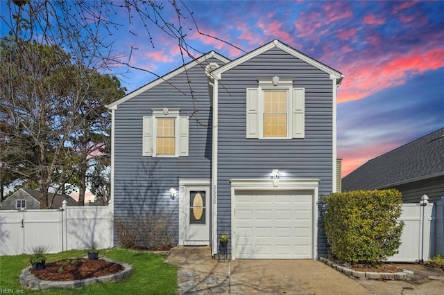 traditional-style house featuring driveway, an attached garage, and fence