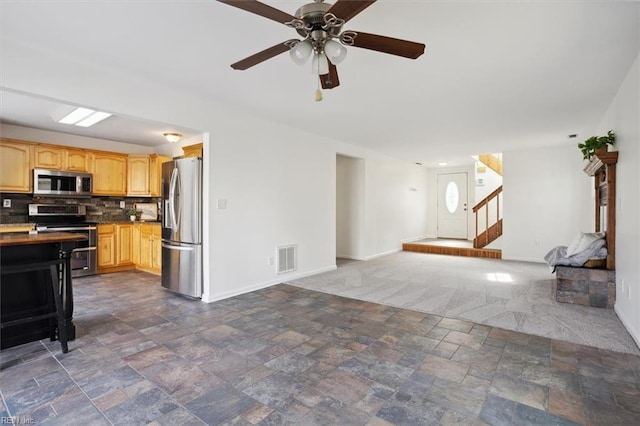 living room featuring dark colored carpet, visible vents, stairway, stone finish floor, and baseboards