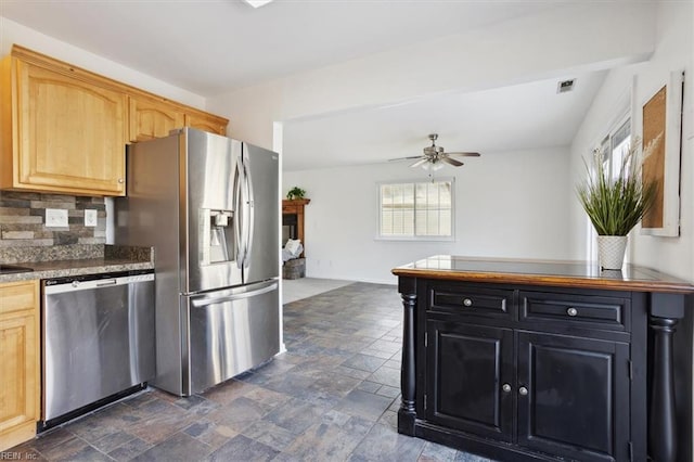 kitchen with appliances with stainless steel finishes, stone finish flooring, decorative backsplash, and a ceiling fan