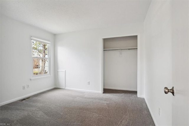 unfurnished bedroom featuring a closet, carpet flooring, visible vents, and baseboards