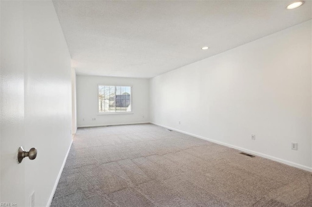 carpeted empty room with recessed lighting, visible vents, and baseboards