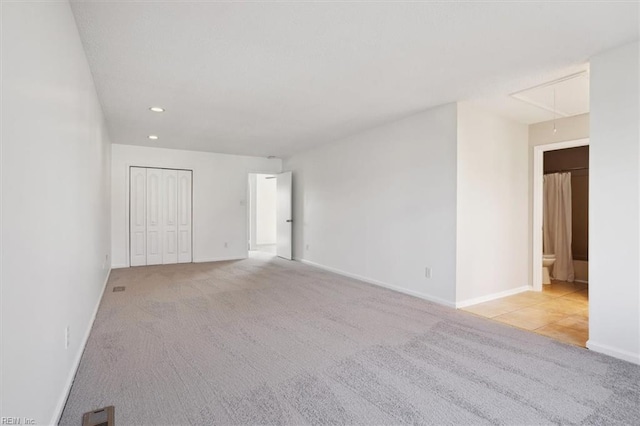 carpeted spare room with attic access, baseboards, and recessed lighting