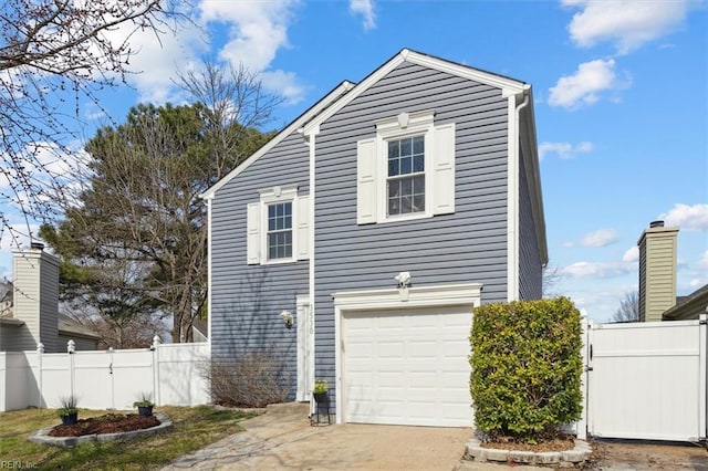 view of side of property with an attached garage, driveway, a gate, and fence