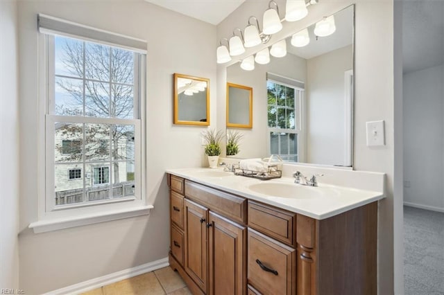 bathroom with tile patterned flooring, a sink, baseboards, and double vanity