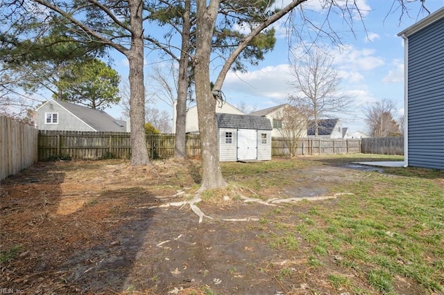 view of yard with a storage unit, an outdoor structure, and a fenced backyard