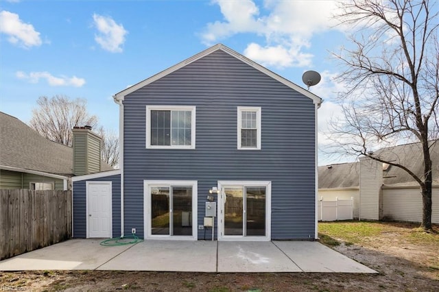 rear view of house with fence and a patio