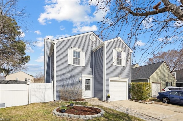 traditional-style home featuring an attached garage, fence, and concrete driveway