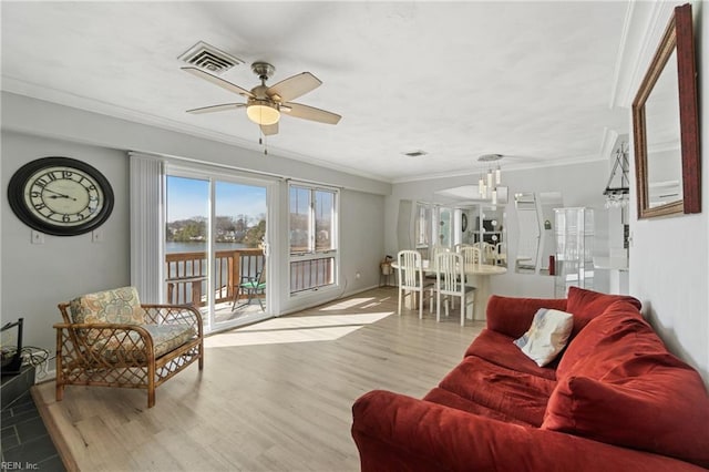 living area featuring ornamental molding, light wood-style flooring, a water view, and visible vents