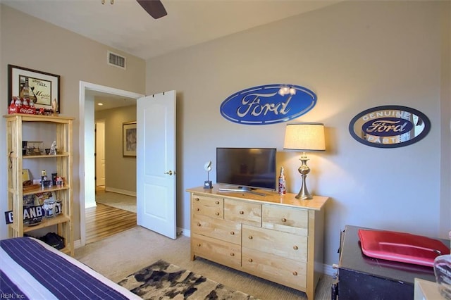 carpeted bedroom with baseboards, visible vents, and a ceiling fan