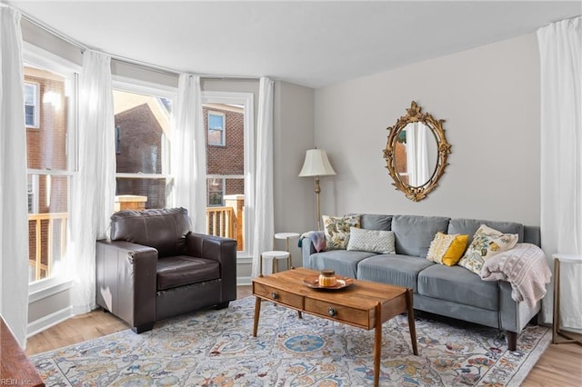 living area featuring light wood-style floors and baseboards